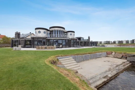 Villa med stor gräsmatta och brygga